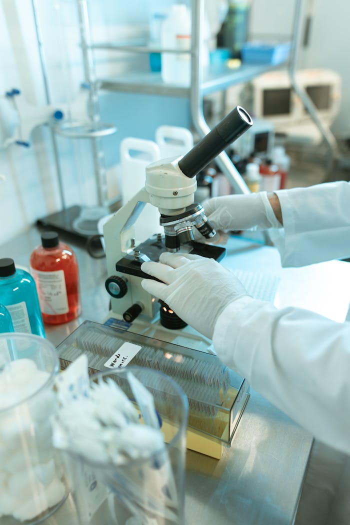 Close-up of a scientist analyzing samples under a microscope in a laboratory.